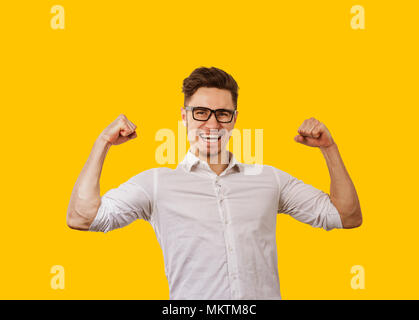 Young man in glasses holding hands up on orange background. Stock Photo