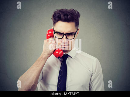 Serious frowning business man having unpleasant telephone conversation Stock Photo
