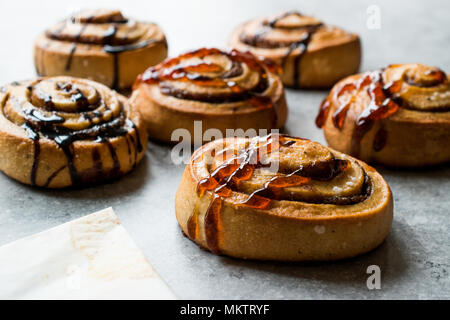 Freshly Baked Cinnamon Rolls with Caramel and Chocolate Sauce. Ready to Eat. Stock Photo