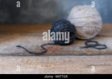 Beige and Grey yarn balls with scissors background, blurred selective focus, toned Stock Photo