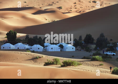 White camping tents among the dunes of the Sahara desert, near the tent people go, Merzouga, Morocco. Stock Photo