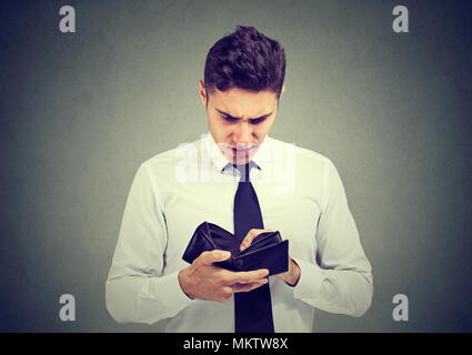 Broke sad business man with empty wallet isolated on gray background Stock Photo