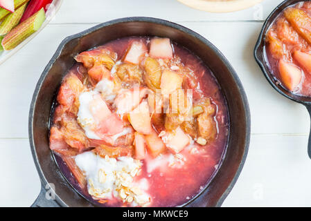 Homemade rhubarb and apple compote for making crumble in the cast iron pans Stock Photo