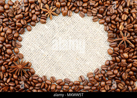 Coffee beans with anisetree stars oval frame on natural sacking background with space for your text. Stock Photo