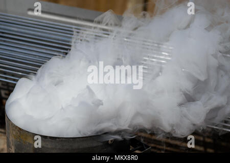 White smoke billowing out of a bbq coal chimney after it has been lit Stock Photo