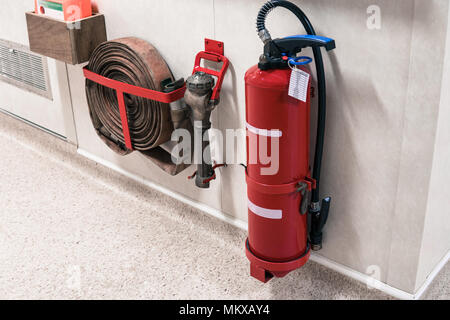 Fire extinguisher and fire hose reel in corridor Stock Photo