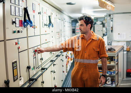 Marine engineer officer starts or stops main engine of ship Stock Photo