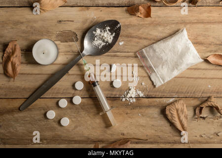 Drug addiction objects rustic wooden background texture with dried autumn leaves - conceptual top view photo Stock Photo