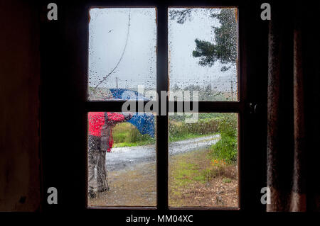 Ardara, County Donegal, Ireland  weather. 9th May 2016. A person struggles to work on a rainy, windy start to the day on Ireland's west coast. Seen through the window of a cottage. Credit: Richard Wayman/Ģ����ý Live News Stock Photo