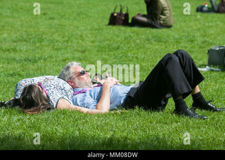 London UK. 9th May 2018. People sunbathing and relaxing the spring sunshine in Victoria Gardens Westminster although temperatures have cooled down after the hot May bank holiday weekend  which saw record temperatures Credit: amer ghazzal/Alamy Live News