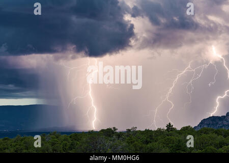 A strong summer thunderstorm with bright lightning bolts and heavy rain moves through the Verde Valley near Sedona, Arizona Stock Photo