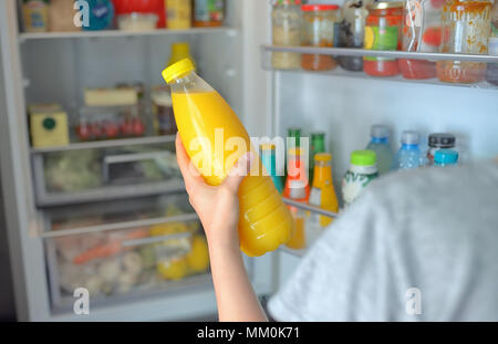 https://l450v.alamy.com/450v/mm0k71/teenage-girl-takes-the-orange-juice-from-the-open-refrigerator-mm0k71.jpg