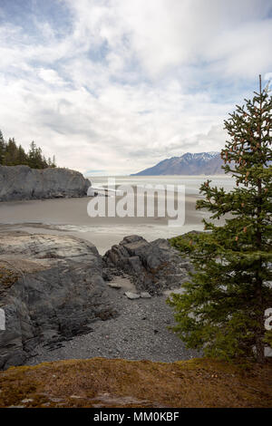 Turnagain Arm, Tidal Flats, Trees, Mountains and Water. Near Hope, Alaska. Rocky Shoreline. Snow capped Chugach Mountains. Kenai Peninsula Windy Point Stock Photo
