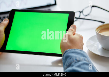 The man's hands with tablet with green chroma key. Work from Home on a Tablet. Stock Photo