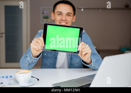 The man's hands with tablet with green chroma key. Work from Home on a Tablet. Stock Photo