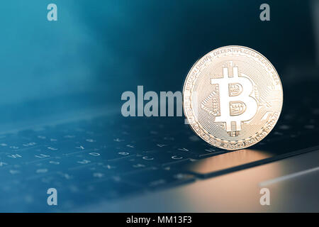 Golden bitcoin on computer keyboard, closeup. Bitcoins and Virtual money. Stock Photo
