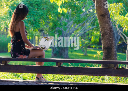 beautiful business woman using laptop in park in day Stock Photo