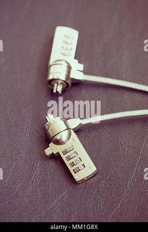 Two computer cable lock on leather, Security concept shot for the digital age Stock Photo