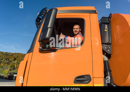 Waste collector driving  Stock Photo