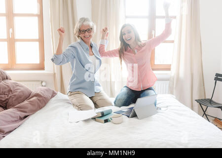 Mother and daughter working together giving high-five Stock Photo