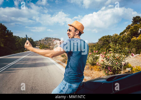 Tourist man making selfie photos in his vacation using phone Stock Photo