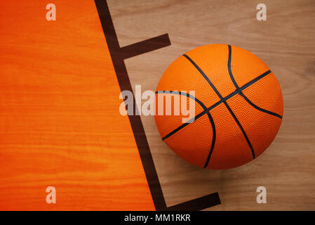 Basketball ball laying on hardwood court floor, top view Stock Photo