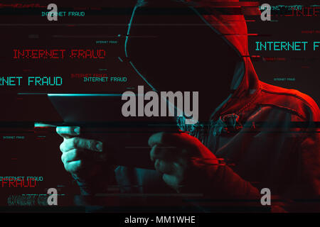 Internet fraud concept with faceless hooded male person using tablet computer, low key red and blue lit image and digital glitch effect Stock Photo