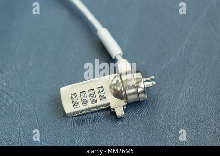 Computer cable lock on black leather, Security concept shot for the digital age Stock Photo