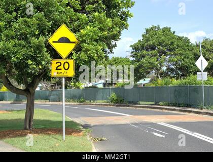 Street sign post with 20 km per hour and speed bump. Yellow road sign to indicate speed limit permitted Stock Photo