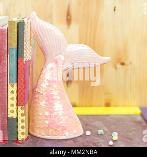 Back to school trend concept with book shelf and mermaid tail Stock Photo