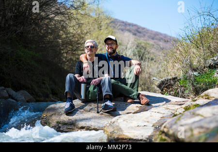 Father and son enjoying nature by the river Stock Photo