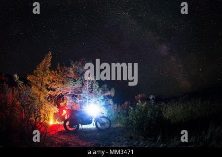 Night camp fire with enduro motorcycle alone traveler landscape steppe on the background of stars and milky way galaxy Altai Mountains Siberia Russia Stock Photo