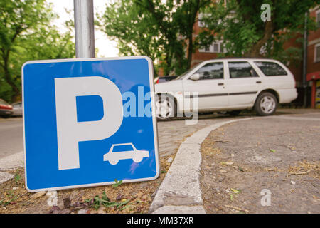 Parking sign with car in blurred background, selective focus Stock Photo