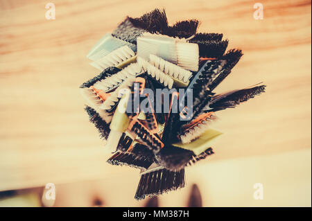 Professional hairdresser tools on table. Toned image. Many brushes for dyeing hair in a glass Stock Photo