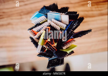 Professional hairdresser tools on table. Toned image. Many brushes for dyeing hair in a glass Stock Photo