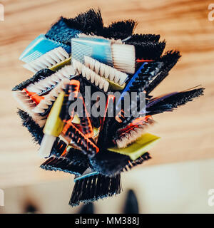 Professional hairdresser tools on table. Toned image. Many brushes for dyeing hair in a glass Stock Photo