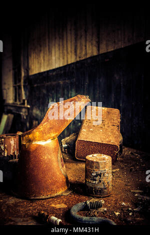 collection of rusty old cans on a workbench in a ruined garage Stock Photo