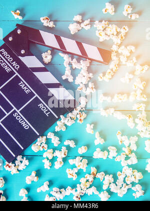 Popcorn and clapperboard on colorful blue background Stock Photo