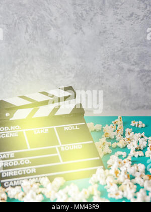 Popcorn and clapperboard on colorful blue background Stock Photo
