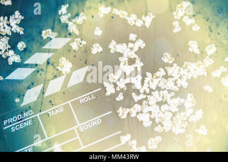 Popcorn and clapperboard on colorful blue background Stock Photo