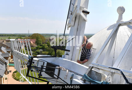 Miller Dave Pearce measures a supporting beam from the storm hatch of Wicken Village windmill in Cambridgeshire as a new sail is fitted to the 19th century smock. Stock Photo