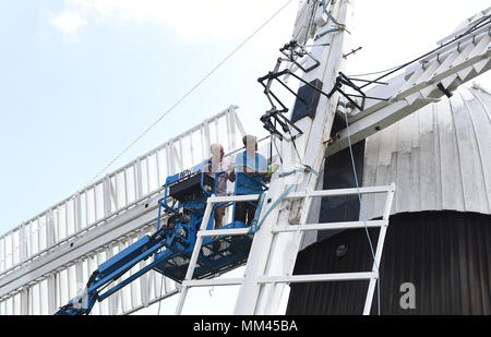 Dan Carrick (left) and millwright Bill Griffths inspect the clamps and supporting beams of Wicken Village windmill in Cambridgeshire as a new sail is fitted to the 19th century smock. Stock Photo