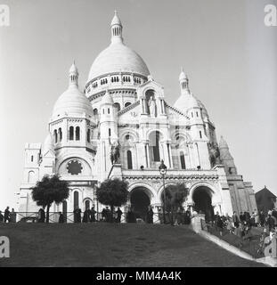 1950s, historical picture of the Basilica of the Sacred Heart of Paris, more commonly known simply as Sacre-Coeur a Roman Catholic Church built on top of the hill of Montmartre, Paris, France. This iconic monument was consecrated in 1919 and is the second most visited religious building in Paris.