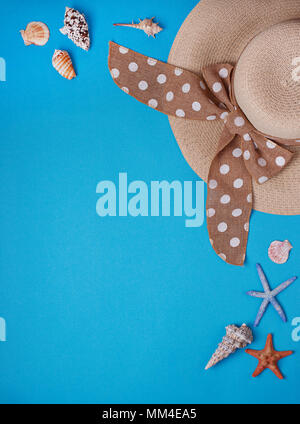 Straw  hat and seashells on blue background Stock Photo