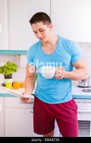 Reading newspaper coffee man in the kitchen portrait format morning smiling Stock Photo