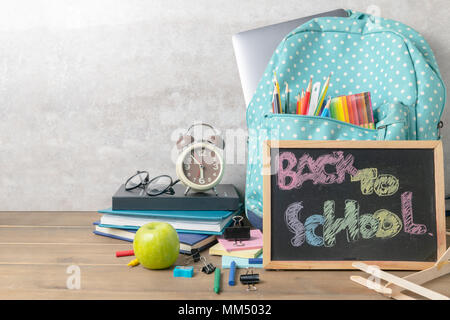 School backpack with coloured pencil and back to school text on blackboard on wood table background. Back to school concept. Stock Photo