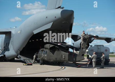 Two UH-60 Blackhawk helicopters from the Kentucky Army National Guard’s 63rd Theater Aviation Brigade are loaded into a U.S. Air Force C-17 Globemaster III aircraft at the Kentucky Air National Guard Base in Louisville, Ky., Sept. 7, 2017 to assist with Hurricane Irma relief efforts. The two army aircraft are equipped with medical evacuation equipment necessary to accomplish search and rescue operations. (U.S. Air Force photo by Staff Sgt. Joshua Horton) Stock Photo