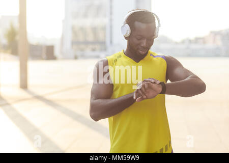 Closeup portrait of african man with berfect body. After jogging counts how many calories burned Stock Photo