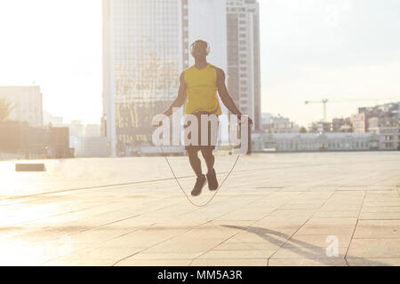 Fly. Boxer training before competitions. Holding jump rope. Outdoor shot Stock Photo