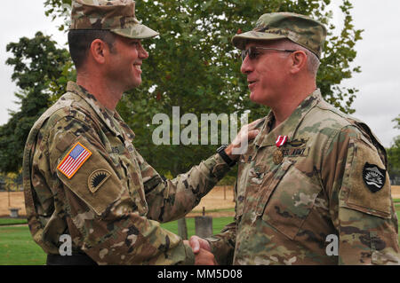 Oregon Army National Guard Col. D. Dean Perez, outgoing commander of the Oregon Training Command, is presented a Meritorious Service Medal from Brig, Gen. William J. Edwards, Land Component Commander, during the change of command ceremony at the Oregon Military Department in Salem, September 10, 2017. (U.S.Army photo by Staff Sgt. Anita VanderMolen, 115th Mobile Public Affairs Detachment) Stock Photo